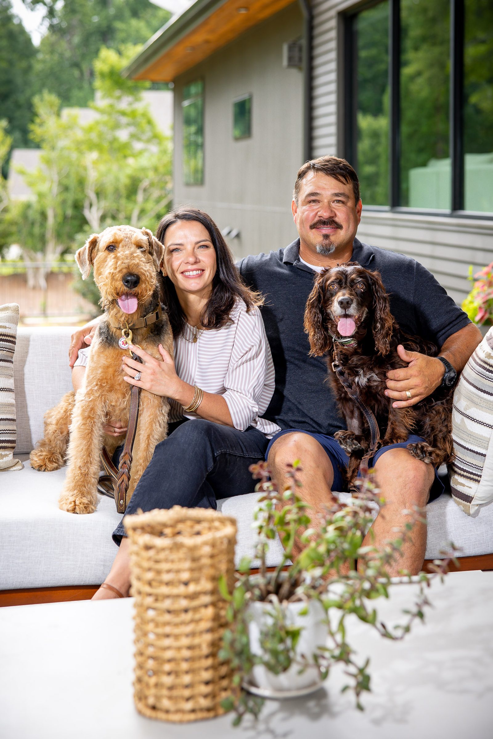 Clay Ortiz, his wife and their two dogs on the back patio of the Sugar Hill home he built for his own family