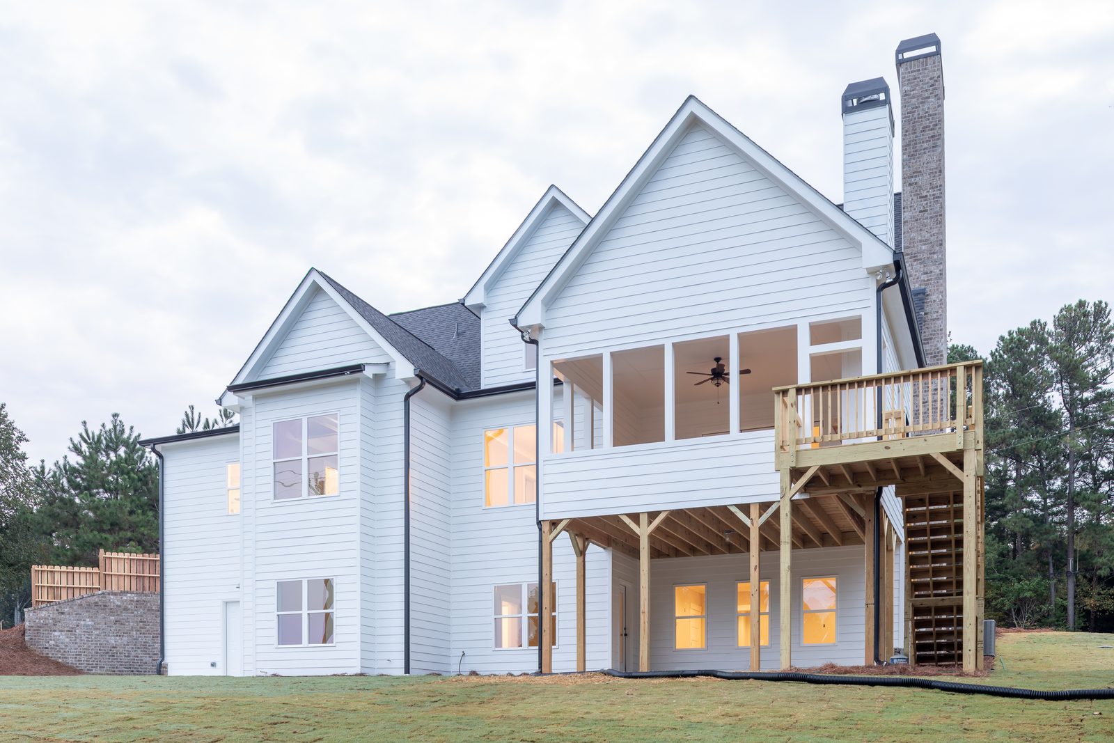 Rear elevation with elevated deck and covered lower porch — Shadburn Ferry, custom home built by Ironwood Construction Group in Buford, Georgia