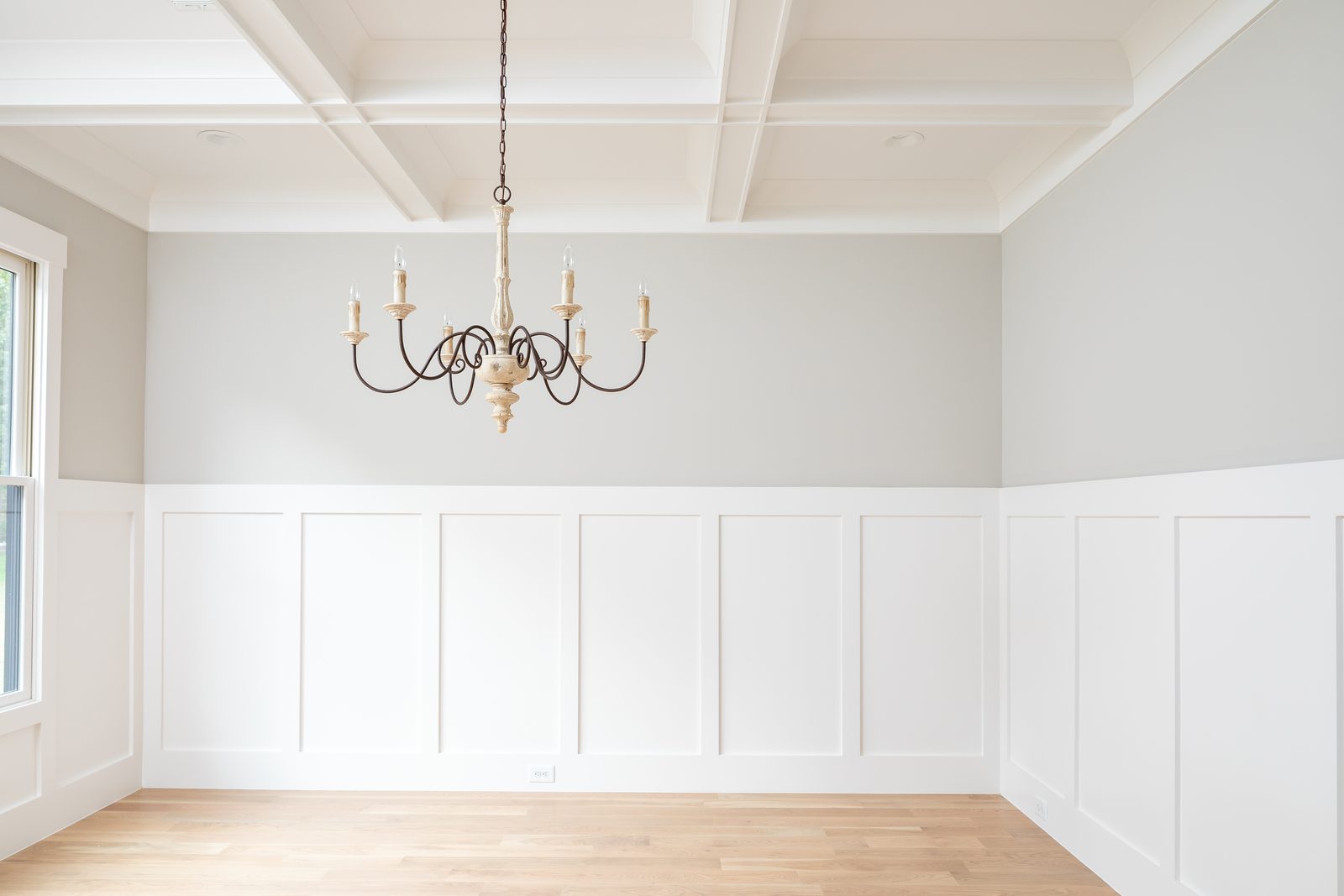 Formal dining room with board-and-batten wainscoting and iron chandelier — Shadburn Ferry, custom home built by Ironwood Construction Group in Buford, Georgia